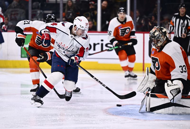 Dec 14, 2023; Philadelphia, Pennsylvania, USA; Washington Capitals center Connor McMichael (24) pushes the puck around Philadelphia Flyers goalie Samuel Ersson (33) for a goal in the second period at Wells Fargo Center. Mandatory Credit: Kyle Ross-USA TODAY Sports