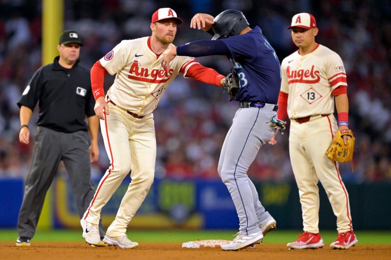 Jul 13, 2024; Anaheim, California, USA;  Ty France #23 of the Seattle Mariners is caught in a run down as he is tagged out by Brandon Drury #23 of the Los Angeles Angels in the fifth inning at Angel Stadium. Mandatory Credit: Jayne Kamin-Oncea-USA TODAY Sports