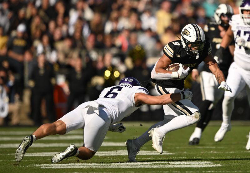 Nov 2, 2024; West Lafayette, Indiana, USA; Purdue Boilermakers wide receiver CJ Smith (9) runs the ball against Northwestern Wildcats defensive back Robert Fitzgerald (6) during the second half at Ross-Ade Stadium. Mandatory Credit: Marc Lebryk-Imagn Images