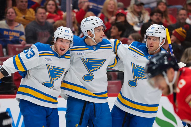 Dec 20, 2025; Sunrise, Florida, USA; St. Louis Blues left wing Jake Neighbours (63) celebrates with defenseman Logan Mailloux (23) and defenseman Cam Fowler (17) after scoring against the Florida Panthers during the first period at Amerant Bank Arena. Mandatory Credit: Sam Navarro-Imagn Images
