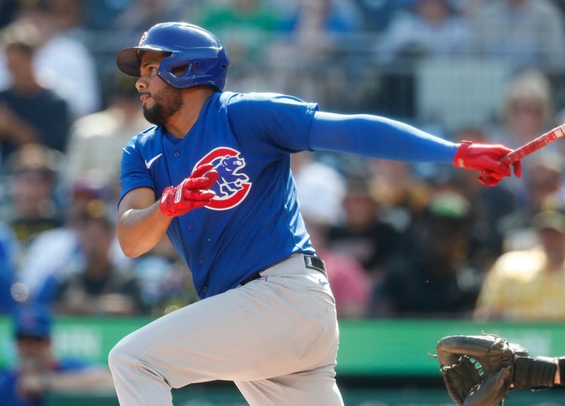 Aug 27, 2023; Pittsburgh, Pennsylvania, USA;  Chicago Cubs third baseman Jeimer Candelario (9) hits an infield RBI single against the Pittsburgh Pirates during the eighth inning at PNC Park. Mandatory Credit: Charles LeClaire-USA TODAY Sports