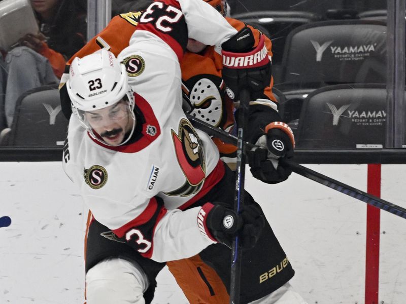 Dec 1, 2024; Anaheim, California, USA;  Ottawa Senators defenseman Travis Hamonic (23) controls the puck with pressure from Anaheim Ducks right wing Frank Vatrano (77) during the second period at Honda Center. Mandatory Credit: Alex Gallardo-Imagn Images