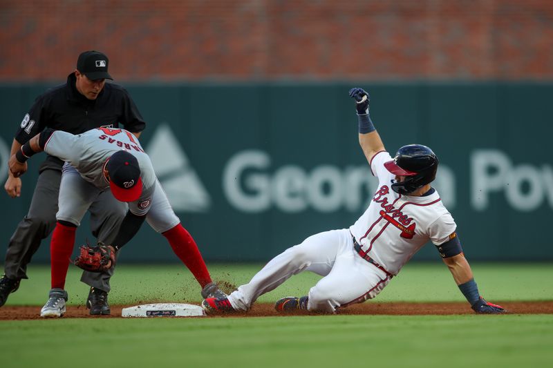 May 28, 2024; Atlanta, Georgia, USA; Atlanta Braves right fielder Adam Duvall (14) slides into second with a double past the tag of Washington Nationals second baseman Ildemaro Vargas (14) in the third inning at Truist Park. Mandatory Credit: Brett Davis-USA TODAY Sports
