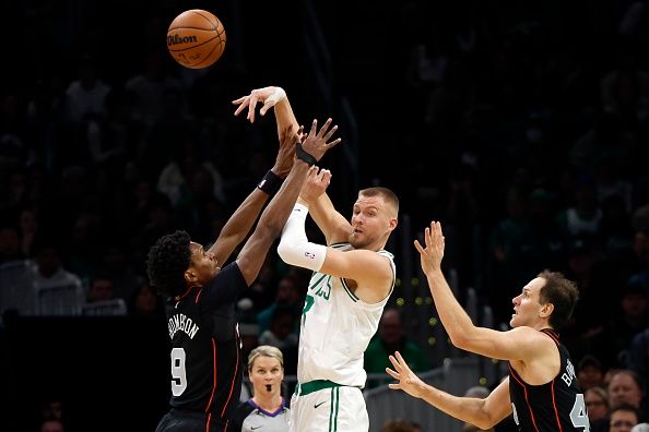 Boston, MA - December 28: Boston Celtics C Kristaps Porzingis passes away from a double team in the second quarter. The Celtics beat the Detroit Pistons, 128-122, in overtime. (Photo by Danielle Parhizkaran/The Boston Globe via Getty Images)