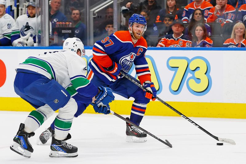 May 12, 2024; Edmonton, Alberta, CAN; Edmonton Oilers forward Connor McDavid (97) carries the puck around Vancouver Canucks defensemen Filip Hornek (17) during the third period in game three of the second round of the 2024 Stanley Cup Playoffs at Rogers Place. Mandatory Credit: Perry Nelson-USA TODAY Sports