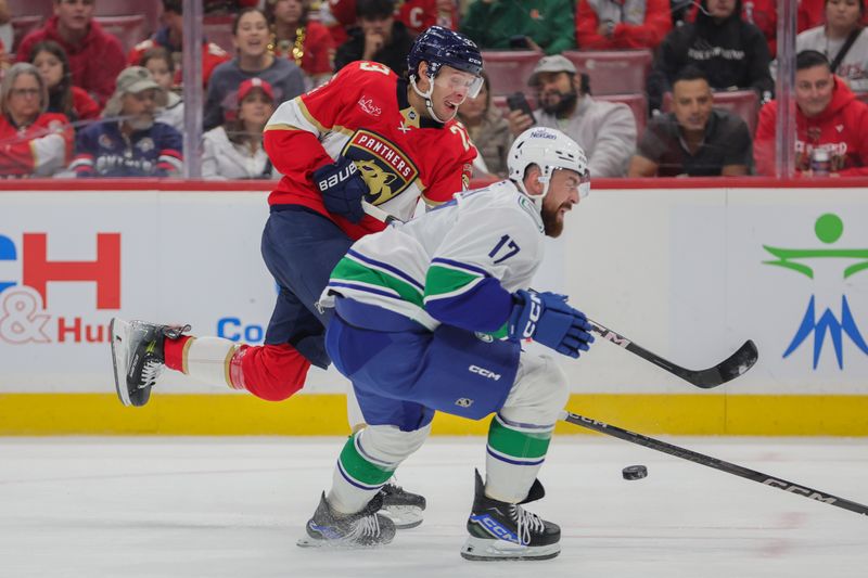 Oct 17, 2024; Sunrise, Florida, USA; Florida Panthers center Carter Verhaeghe (23) shoots the puck as Vancouver Canucks defenseman Filip Hronek (17) defends during the first period at Amerant Bank Arena. Mandatory Credit: Sam Navarro-Imagn Images