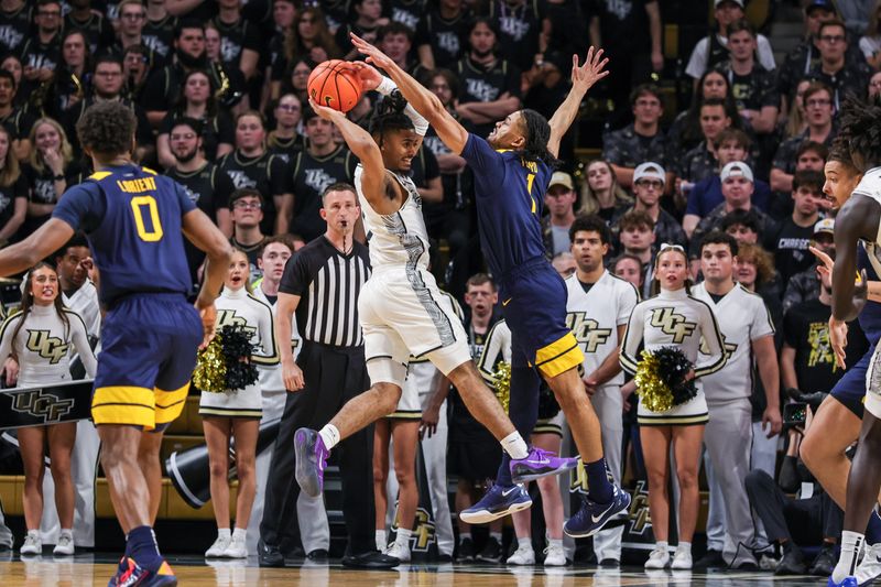 Feb 14, 2026; Orlando, Florida, USA; UCF Knights guard Riley Kugel (2) passes against West Virginia Mountaineers guard Jasper Floyd (1) during the first half at Addition Financial Arena. Mandatory Credit: Mike Watters-Imagn Images