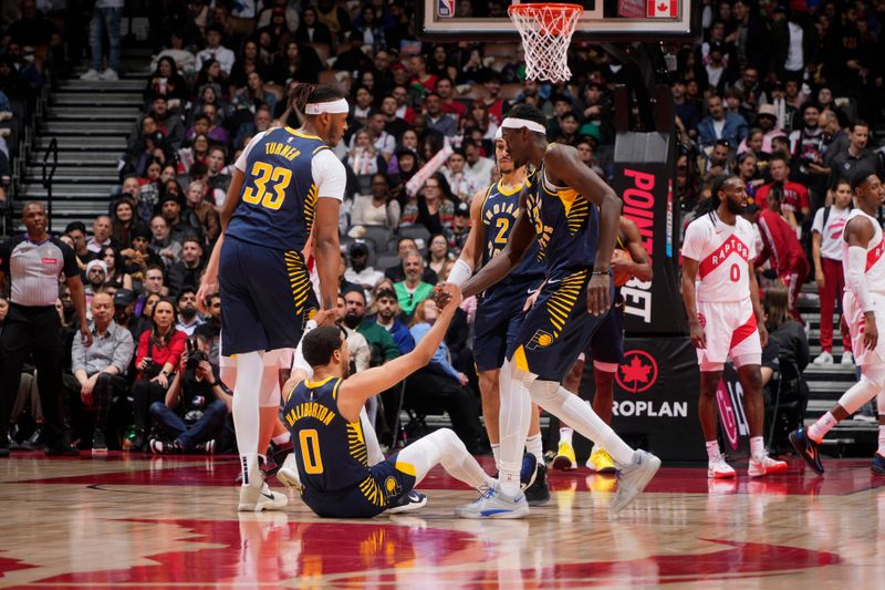 TORONTO, CANADA - APRIL 9: Myles Turner #33 and Pascal Siakam #43 help up Tyrese Haliburton #0 of the Indiana Pacers during the game against the Toronto Raptors on April 9, 2024 at the Scotiabank Arena in Toronto, Ontario, Canada.  NOTE TO USER: User expressly acknowledges and agrees that, by downloading and or using this Photograph, user is consenting to the terms and conditions of the Getty Images License Agreement.  Mandatory Copyright Notice: Copyright 2024 NBAE (Photo by Mark Blinch/NBAE via Getty Images)