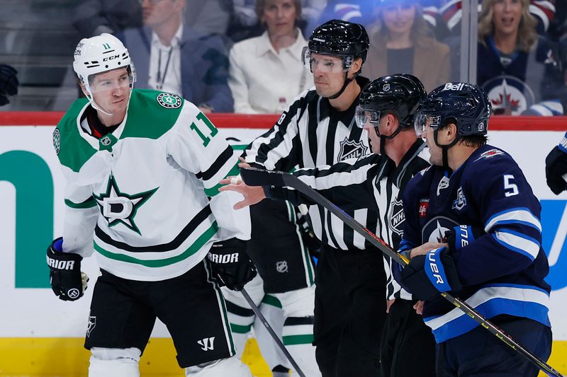 Oct 9, 2025; Winnipeg, Manitoba, CAN; Dallas Stars right wing Nathan Bastian (11) and Winnipeg Jets defenseman Luke Schenn (5) are separated during an altercation in the third period at Canada Life Centre. Mandatory Credit: James Carey Lauder-Imagn Images