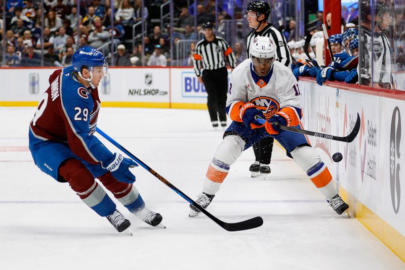 Oct 14, 2024; Denver, Colorado, USA; New York Islanders left wing Anthony Duclair (11) and Colorado Avalanche center Nathan MacKinnon (29) battle for the puck in the first period at Ball Arena. Mandatory Credit: Isaiah J. Downing-Imagn Images