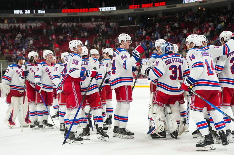 Nov 26, 2025; Raleigh, North Carolina, USA; New York Rangers players celebrate the win against the Carolina Hurricanes at Lenovo Center. Mandatory Credit: James Guillory-Imagn Images