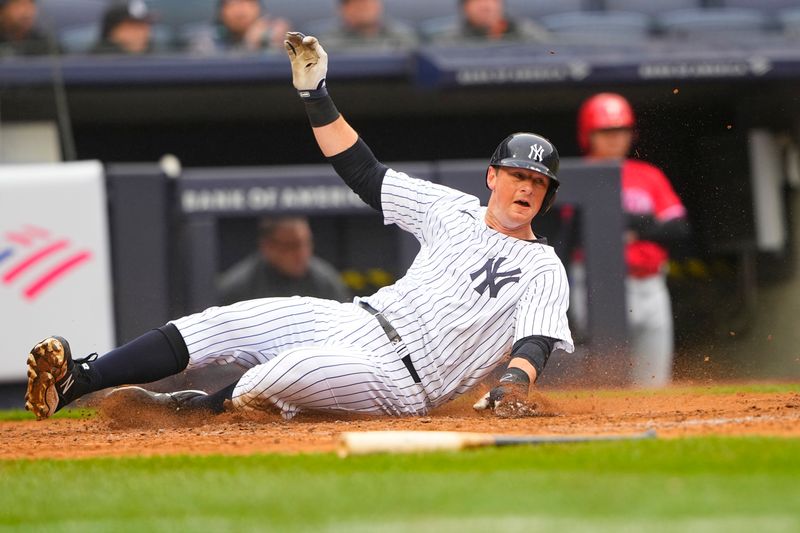 Apr 5, 2023; Bronx, New York, USA; New York Yankees second baseman DJ LeMahieu (26) slides safely into home plate on New York Yankees designated hitter Gleybor Torres (25) (not pictured) RBI single against the Philadelphia Phillies during the sixth inning at Yankee Stadium. Mandatory Credit: Gregory Fisher-USA TODAY Sports