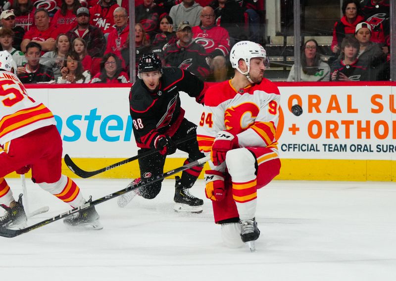 Mar 10, 2024; Raleigh, North Carolina, USA;  Calgary Flames defenseman Brayden Pachal (94) blocks the shot by Carolina Hurricanes center Martin Necas (88) during the first period at PNC Arena. Mandatory Credit: James Guillory-USA TODAY Sports