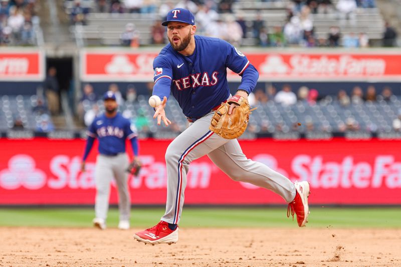 May 22, 2025; Bronx, New York, USA; Texas Rangers first baseman Jake Burger (21) throws the ball to first base for an out during the third inning against the New York Yankees at Yankee Stadium. Mandatory Credit: Vincent Carchietta-Imagn Images