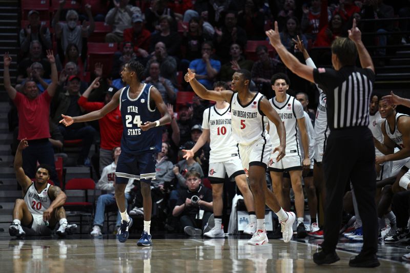 Jan 25, 2023; San Diego, California, USA; San Diego State Aztecs guard Lamont Butler (5) gestures after a three-point basket during the second half as Utah State Aggies forward Zee Hamoda (24) reacts at Viejas Arena. Mandatory Credit: Orlando Ramirez-USA TODAY Sports