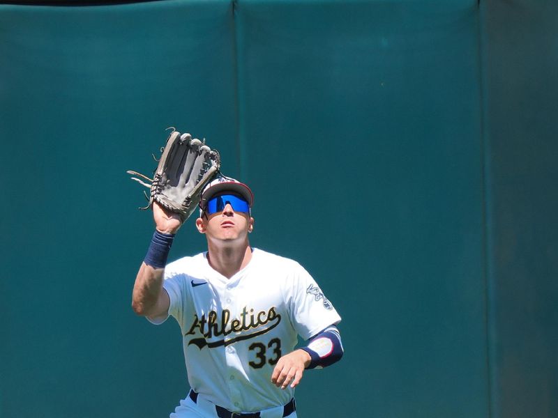 Jul 4, 2024; Oakland, California, USA; Oakland Athletics center fielder JJ Bleday (33) catches the ball against the Los Angeles Angels during the sixth inning at Oakland-Alameda County Coliseum. Mandatory Credit: Kelley L Cox-USA TODAY Sports