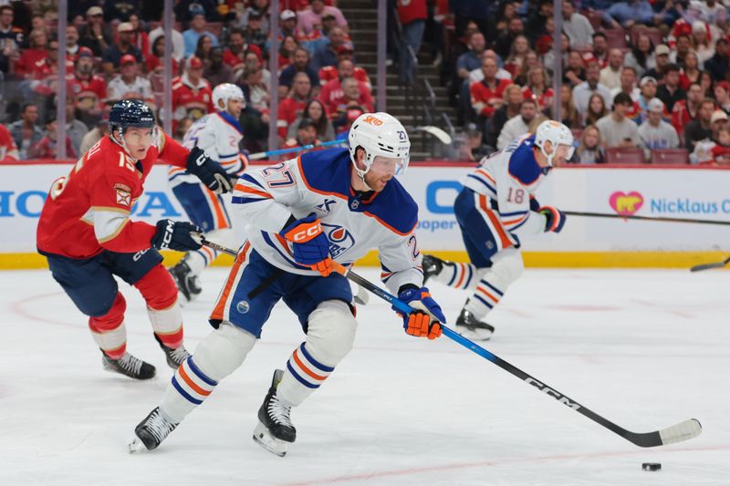 Nov 22, 2025; Sunrise, Florida, USA; Edmonton Oilers defenseman Brett Kulak (27) moves the puck against Florida Panthers center Anton Lundell (15) during the first period at Amerant Bank Arena. Mandatory Credit: Sam Navarro-Imagn Images