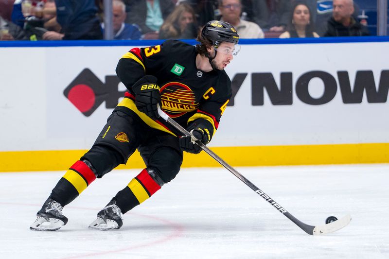 Jan 25, 2025; Vancouver, British Columbia, CAN; Vancouver Canucks defenseman Quinn Hughes (43) handles the puck against the Washington Capitals in the third period at Rogers Arena. Mandatory Credit: Bob Frid-Imagn Images