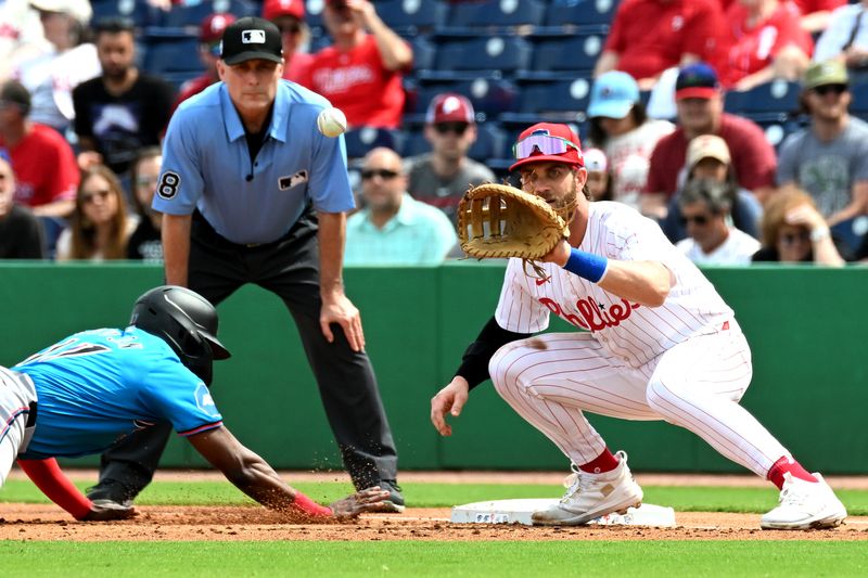 Mar 1, 2024; Clearwater, Florida, USA; Philadelphia Phillies first baseman Bryce Harper (3) waits for the ball as Miami Marlins second baseman Vital Brujan (17) dives back to the base in the first inning of the spring training game at BayCare Ballpark. Mandatory Credit: Jonathan Dyer-USA TODAY Sports