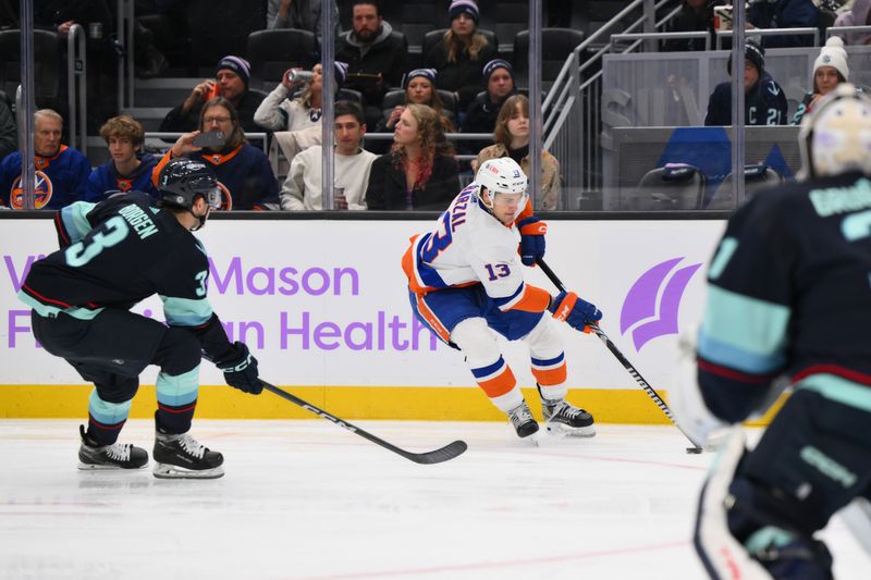 Nov 16, 2023; Seattle, Washington, USA; New York Islanders center Mathew Barzal (13) plays the puck while defended by Seattle Kraken defenseman Will Borgen (3) during the second period at Climate Pledge Arena. Mandatory Credit: Steven Bisig-USA TODAY Sports