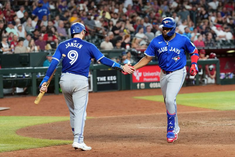 Jul 14, 2024; Phoenix, Arizona, USA; Toronto Blue Jays first base Vladimir Guerrero Jr. (27) slaps hands with Toronto Blue Jays catcher Danny Jansen (9) after hitting a solo home run against the Arizona Diamondbacks during the seventh inning at Chase Field. Mandatory Credit: Joe Camporeale-USA TODAY Sports