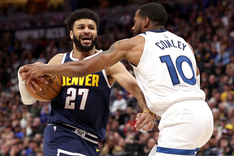 DENVER, COLORADO - APRIL 10: Jamal Murray #27 of the Denver Nuggets drives against Mike Conley #10 of the Minnesota Timberwolves during the first quarter at Ball Arena on April 10, 2024 in Denver, Colorado. NOTE TO USER: User expressly acknowledges and agrees that, by downloading and or using this photograph, User is consenting to the terms and conditions of the Getty Images License Agreement.  (Photo by Matthew Stockman/Getty Images)