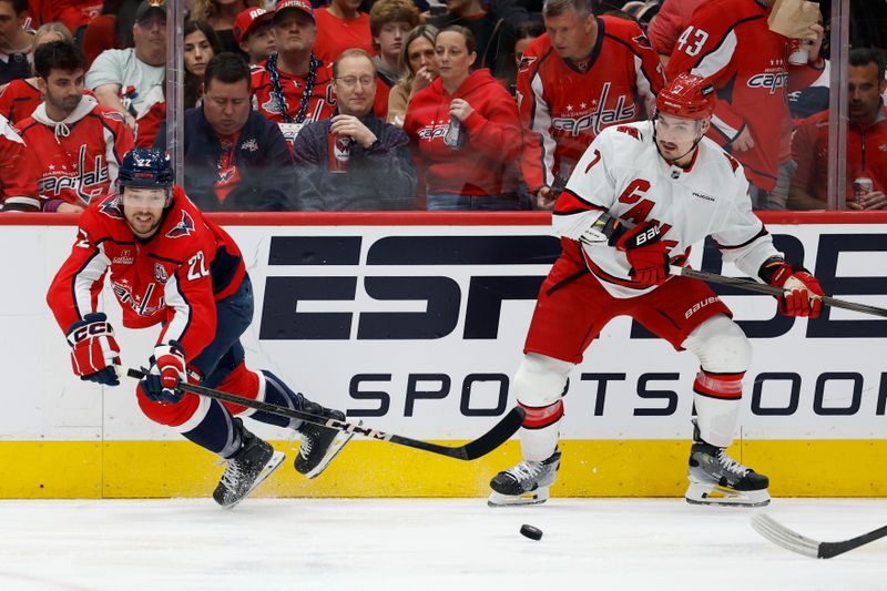 May 8, 2025; Washington, District of Columbia, USA; Washington Capitals right wing Brandon Duhaime (22) clears the puck from Carolina Hurricanes defenseman Dmitry Orlov (7) in the second period in game two of the second round of the 2025 Stanley Cup Playoffs at Capital One Arena. Mandatory Credit: Geoff Burke-Imagn Images