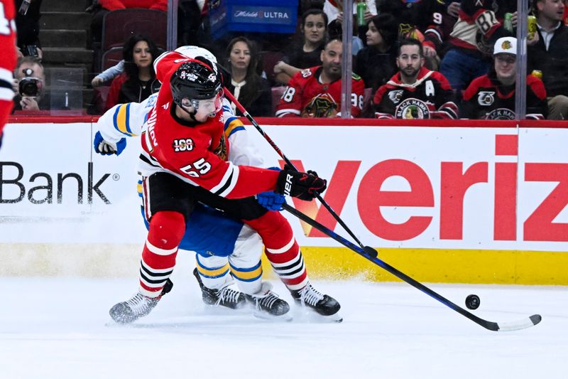 Jan 7, 2026; Chicago, Illinois, USA; Chicago Blackhawks defenseman Artyom Levshunov (55) moves the puck against St. Louis Blues right wing Jordan Kyrou (25) during the first period at the United Center. Mandatory Credit: Matt Marton-Imagn Images