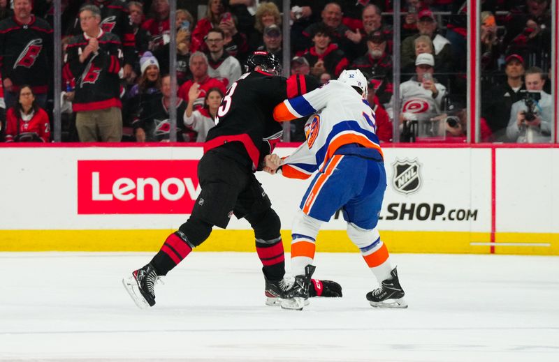 Apr 22, 2024; Raleigh, North Carolina, USA; Carolina Hurricanes right wing Stefan Noesen (23) and New York Islanders center Kyle MacLean (32) fight during the first period in game two of the first round of the 2024 Stanley Cup Playoffs at PNC Arena. Mandatory Credit: James Guillory-USA TODAY Sports