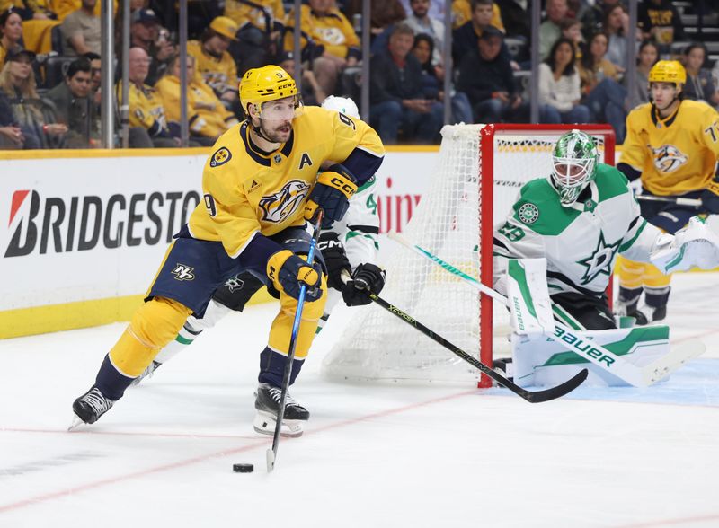 Nov 8, 2025; Nashville, Tennessee, USA; Nashville Predators left wing Filip Forsberg (9) moves the puck as Dallas Stars goal tender Jake Oettinger (29) covers the goal during the third period at Bridgestone Arena. Mandatory Credit: Alan Poizner-Imagn Images