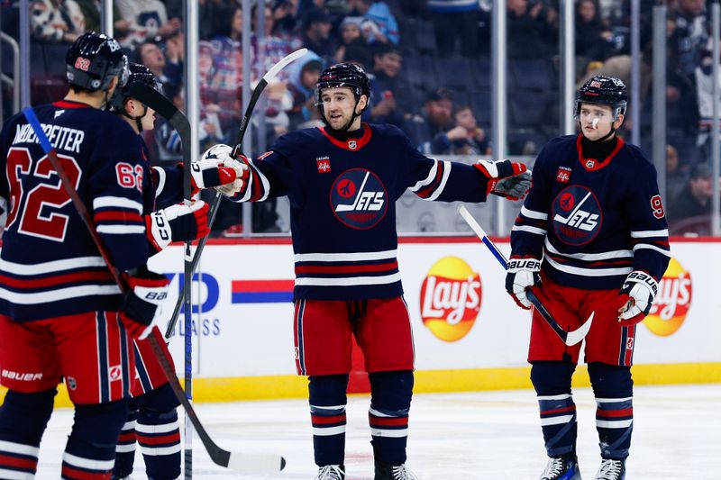 Jan 14, 2025; Winnipeg, Manitoba, CAN;  Winnipeg Jets defenseman Neal Pionk (4) celebrates his goal against the Vancouver Canucks during the second period at Canada Life Centre. Mandatory Credit: Terrence Lee-Imagn Images