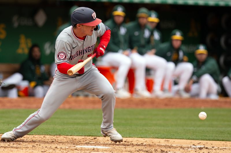 Apr 13, 2024; Oakland, California, USA; Washington Nationals center fielder Jacob Young (30) drops a sacrifice bunt against the Oakland Athletics during the fifth inning at Oakland-Alameda County Coliseum. Mandatory Credit: D. Ross Cameron-USA TODAY Sports