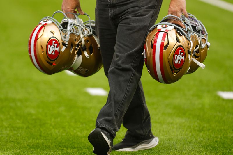 San Francisco 49ers helmets are carried on the field before an NFL football game against the Minnesota Vikings, Sunday, Sept. 15, 2024, in Minneapolis. (AP Photo/Bruce Kluckhohn)