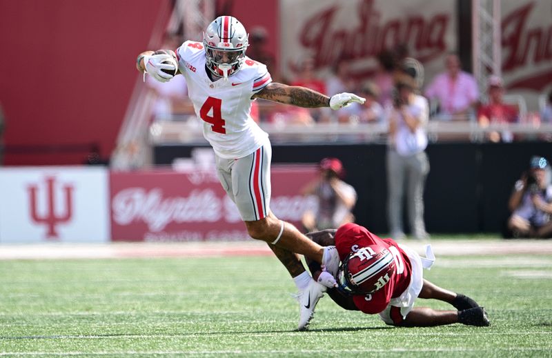 Sep 2, 2023; Bloomington, Indiana, USA; Ohio State Buckeyes wide receiver Julian Fleming (4) is tackled by Indiana Hoosiers defensive back Kobee Minor (5) during the second quarter at Memorial Stadium. Mandatory Credit: Marc Lebryk-USA TODAY Sports