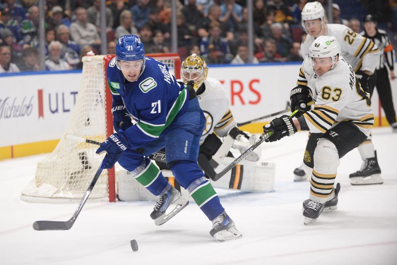 Feb 24, 2024; Vancouver, British Columbia, CAN;  Vancouver Canucks forward Nils Hoglander (21) controls the puck against Boston Bruins forward Brad Marchand (63) during the third period at Rogers Arena. Mandatory Credit: Anne-Marie Sorvin-USA TODAY Sports