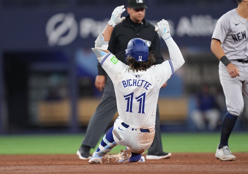 Apr 17, 2024; Toronto, Ontario, CAN; Toronto Blue Jays shortstop Bo Bichette (11) slides into second base safe against the New York Yankees during the sixth inning at Rogers Centre. Mandatory Credit: Nick Turchiaro-USA TODAY Sports