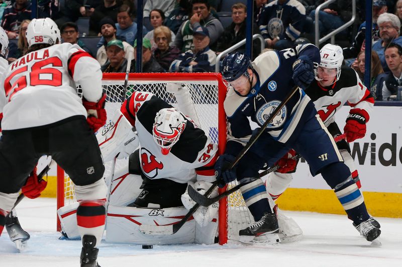 Mar 17, 2025; Columbus, Ohio, USA; New Jersey Devils goalie Jake Allen (34) stops the wrap around attempt of Columbus Blue Jackets center Mathieu Olivier (24) during the third period at Nationwide Arena. Mandatory Credit: Russell LaBounty-Imagn Images