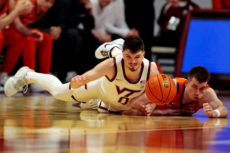 Jan 10, 2024; Blacksburg, Virginia, USA; Virginia Tech Hokies guard Hunter Cattoor (0) and Clemson Tigers guard Joseph Girard III (11) go for the ball during the first half at Cassell Coliseum. Mandatory Credit: Peter Casey-USA TODAY Sports