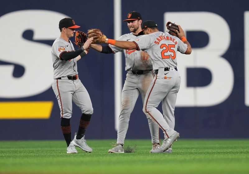 Jun 3, 2024; Toronto, Ontario, CAN; Baltimore Orioles left fielder Austin Hays (21) and center fielder Colton Cowser (17) and right fielder Anthony Santander (25) celebrate the win against the Toronto Blue Jays at the end of the ninth inning at Rogers Centre. Mandatory Credit: Nick Turchiaro-USA TODAY Sports