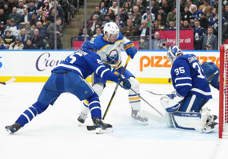 Mar 6, 2024; Toronto, Ontario, CAN; Buffalo Sabres right wing Kyle Okposo (21) battles for the puck with Toronto Maple Leafs defenseman William Lagesson (85) in front of  goaltender Ilya Samsonov (35) during the second period at Scotiabank Arena. Mandatory Credit: Nick Turchiaro-USA TODAY Sports