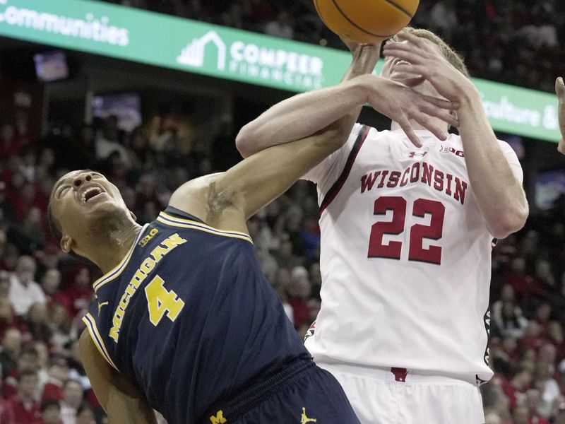 Dec 3, 2024; Madison, Wisconsin, USA; Michigan guard Nimari Burnett (4) tries to score on Wisconsin forward Steven Crowl (22) during the first half of their game Tuesday, December 3, 2024 at the Kohl Center in Madison, Wisconsin.  Mandatory Credit: Mark Hoffman/USA TODAY Network via Imagn Images 