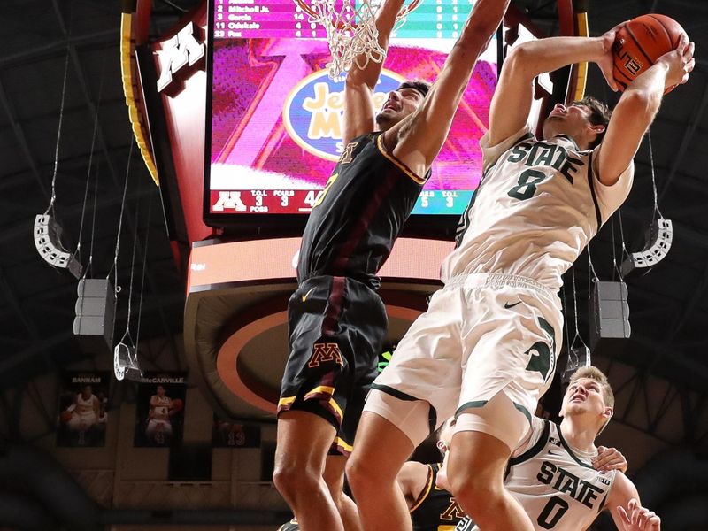 Dec 4, 2024; Minneapolis, Minnesota, USA; Michigan State Spartans guard Tre Holloman (5) shoots as Minnesota Golden Gophers forward Dawson Garcia (3) defends during the second half at Williams Arena. Mandatory Credit: Matt Krohn-Imagn Images