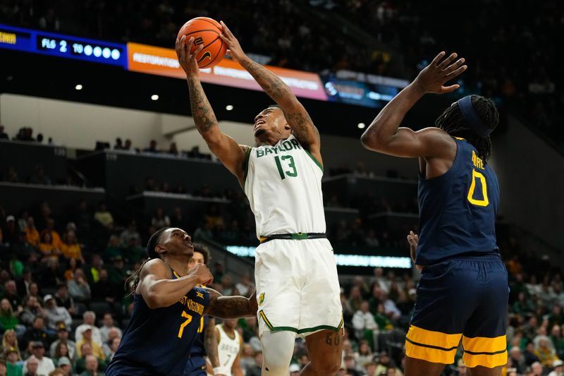 Feb 15, 2025; Waco, Texas, USA; Baylor Bears guard Langston Love (13) drives to the basket ahead of West Virginia Mountaineers center Eduardo Andre (0) during the first half at Paul and Alejandra Foster Pavilion. Mandatory Credit: Chris Jones-Imagn Images