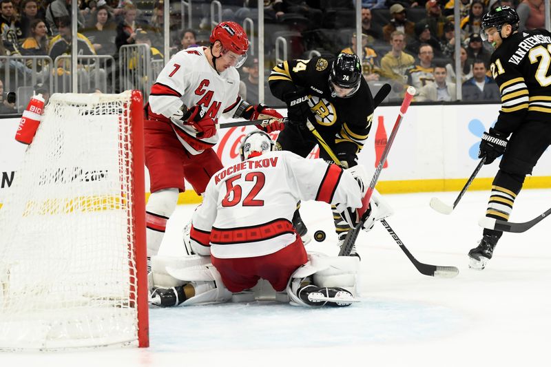 Apr 9, 2024; Boston, Massachusetts, USA; Carolina Hurricanes defenseman Dmitry Orlov (7) and Boston Bruins left wing Jake DeBrusk (74) battle for the puck in front of goaltender Pyotr Kochetkov (52) during the third period at TD Garden. Mandatory Credit: Bob DeChiara-USA TODAY Sports