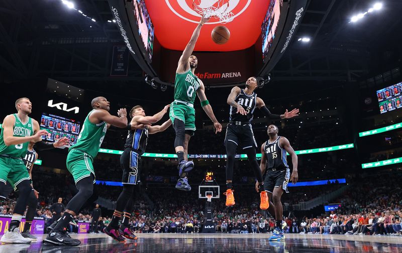 ATLANTA, GEORGIA - MARCH 25:  Jayson Tatum #0 of the Boston Celtics dunks against Dejounte Murray #5 and Bogdan Bogdanovic #13 of the Atlanta Hawks during the fourth quarter at State Farm Arena on March 25, 2024 in Atlanta, Georgia.  NOTE TO USER: User expressly acknowledges and agrees that, by downloading and/or using this photograph, user is consenting to the terms and conditions of the Getty Images License Agreement. (Photo by Kevin C. Cox/Getty Images)