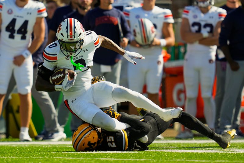 Oct 19, 2024; Columbia, Missouri, USA; Auburn Tigers running back Damari Alston (0) is tackled by Missouri Tigers cornerback Ja'Marion Wayne (25) during the second half at Faurot Field at Memorial Stadium. Mandatory Credit: Jay Biggerstaff-Imagn Images
