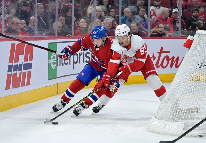 Apr 16, 2024; Montreal, Quebec, CAN; Detroit Red Wings forward Alex DeBrincat (93) plays the puck and Montreal Canadiens defenseman Lane Hutson (48) defends during the first period at the Bell Centre. Mandatory Credit: Eric Bolte-USA TODAY Sports