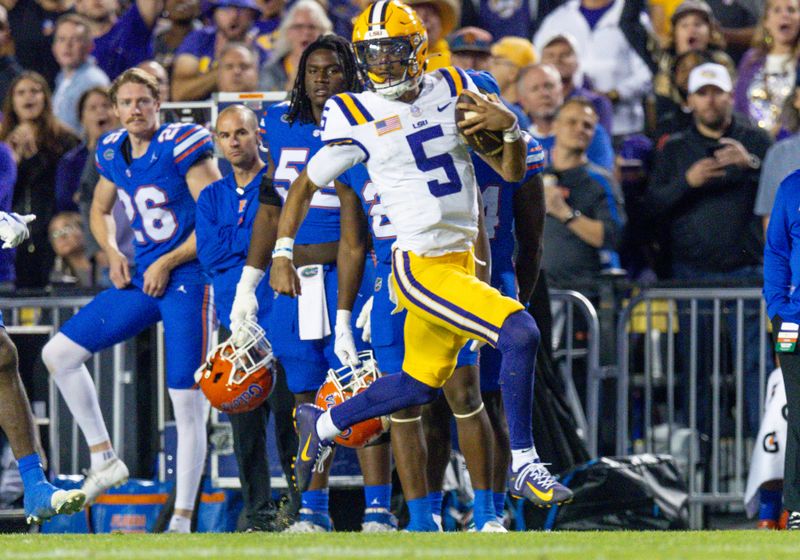 Nov 11, 2023; Baton Rouge, Louisiana, USA;  LSU Tigers quarterback Jayden Daniels (5) rushes for a touchdown against the Florida Gators during the first half at Tiger Stadium. Mandatory Credit: Stephen Lew-USA TODAY Sports