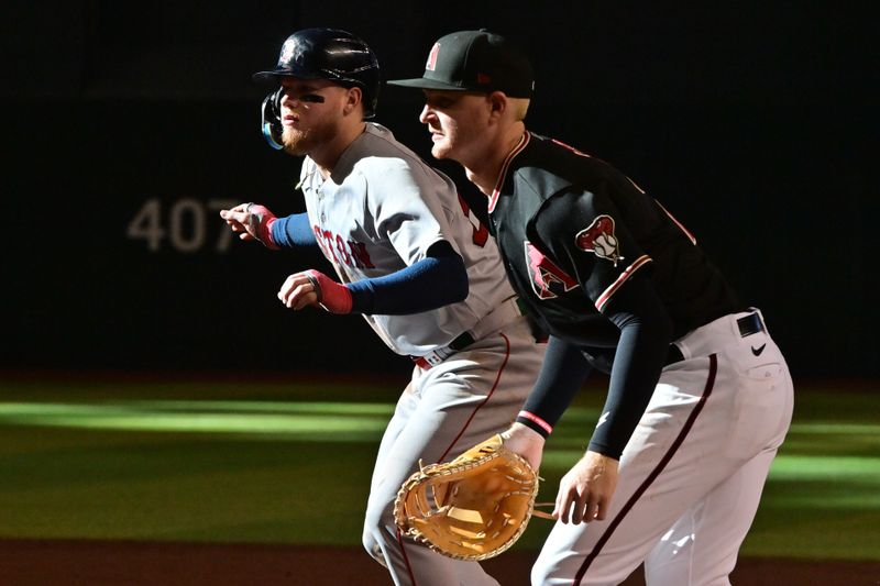 May 27, 2023; Phoenix, Arizona, USA;  Boston Red Sox right fielder Alex Verdugo (99) leads off against Arizona Diamondbacks first baseman Pavin Smith (26) in the third inning at Chase Field. Mandatory Credit: Matt Kartozian-USA TODAY Sports