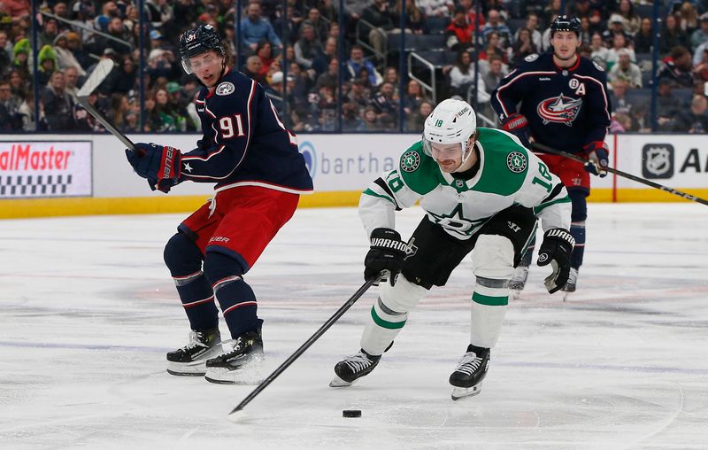 Feb 25, 2025; Columbus, Ohio, USA; Dallas Stars center Sam Steel (18) picks up a loose puck against Columbus Blue Jackets center Kent Johnson (91) during the second period at Nationwide Arena. Mandatory Credit: Russell LaBounty-Imagn Images